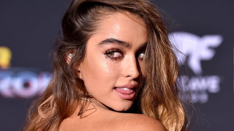 Sommer Ray sends a sultry look over her shoulder while wearing a tan dress