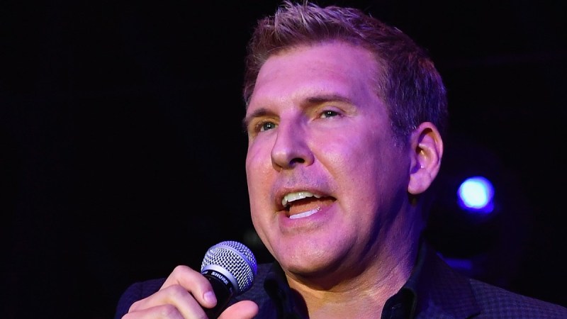 Todd Chrisley wears all black and addresses a crowd from the stage