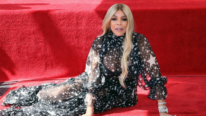 Wendy Williams wears a black dress and poses next to her Walk of Fame star