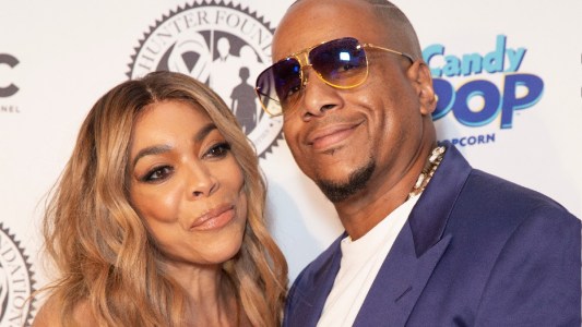 Wendy Williams wears a beige dress and poses with now ex husband Kevin Hunter, in a blue suit jacket