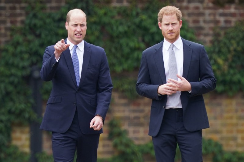 Prince William and Prince Harry walking together in navy suits