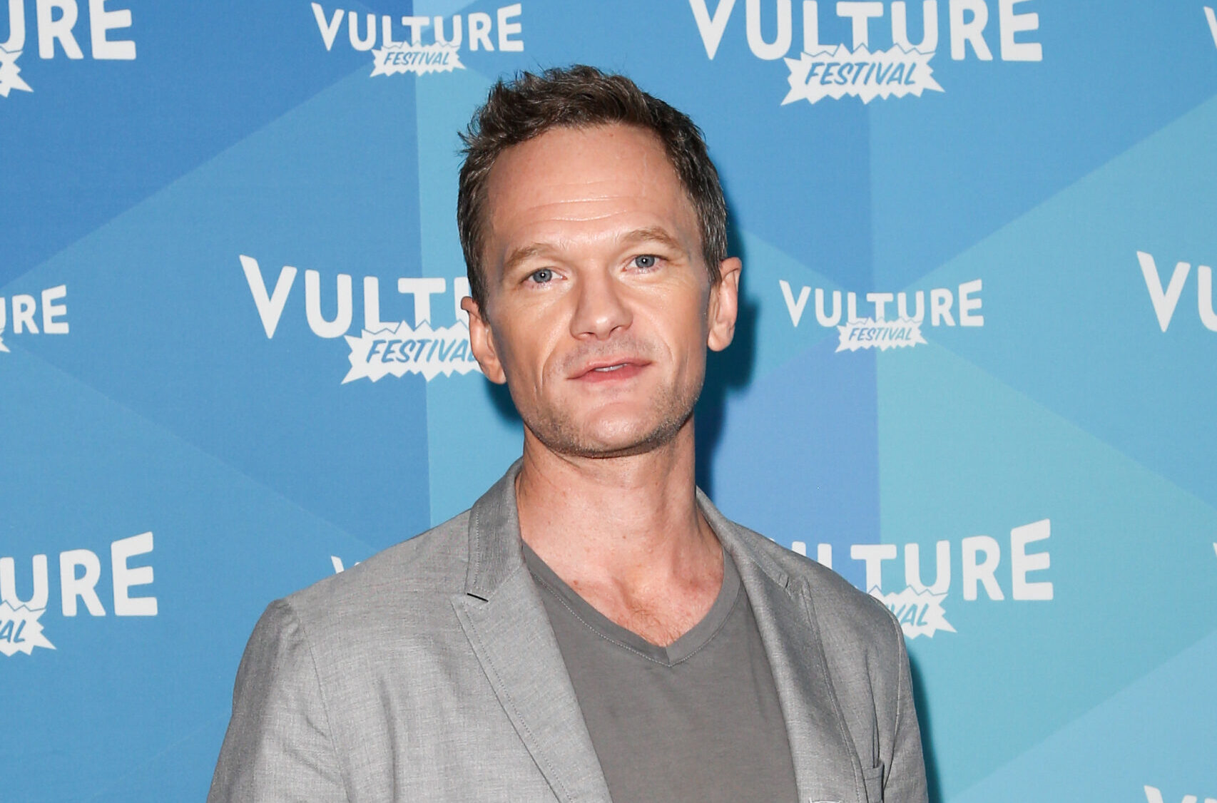 Neil Patrick Harris wearing a grey shirt and jacket