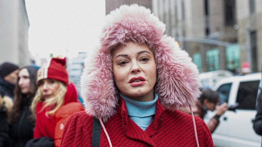Rose McGowan wears a red coat and pink furry hat while walking in New York City