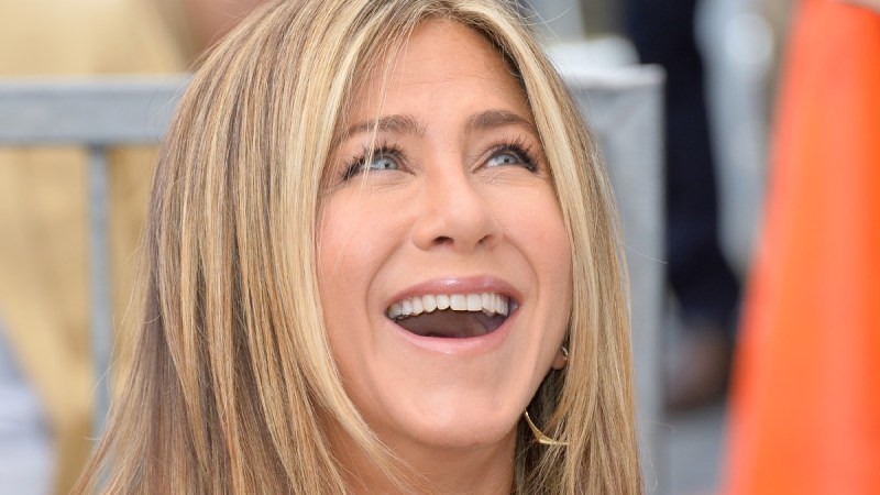 Jennifer Aniston smiles up at someone during a Hollywood Walk Of Fame ceremony