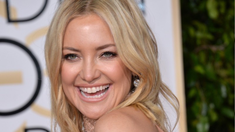 Kate Hudson looks over her shoulder and laughs on the red carpet