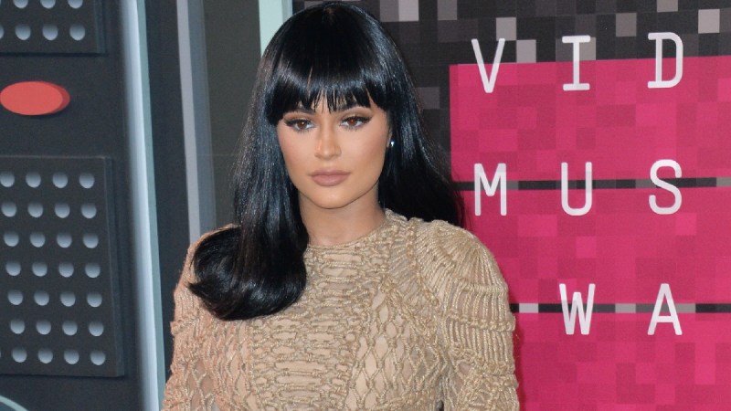 Kylie Jenner wears a black wig and a tan dress on the red carpet