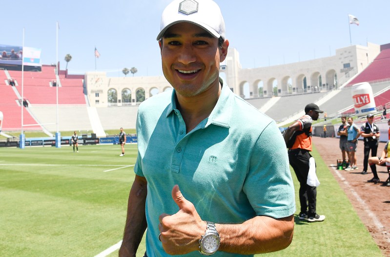 Mario Lopez in a football stadium giving a thumbs up.
