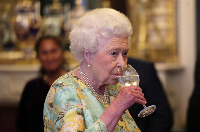 Queen Elizabeth drinking from a wine glass.