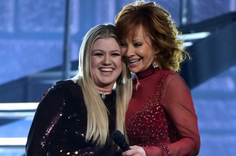 Kelly Clarkson and Reba McEntire hugging after a performance together.