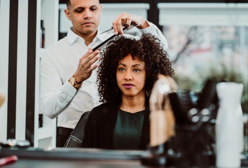 Woman with natural curls getting a haircut.