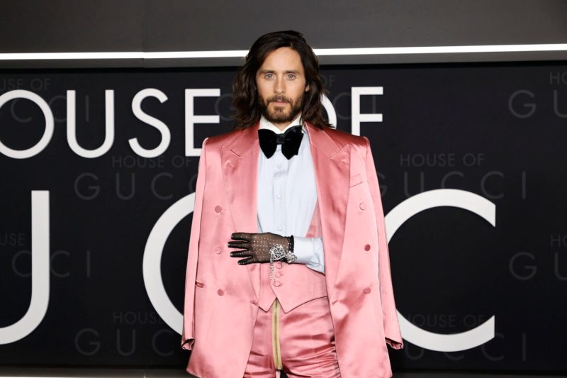 Jared Leto poses on the red carpet wearing a velvet pink tuxedo and pink cape jacket