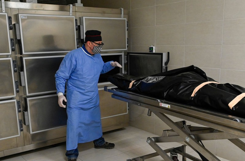 The inside of a morgue with a body in a body bag