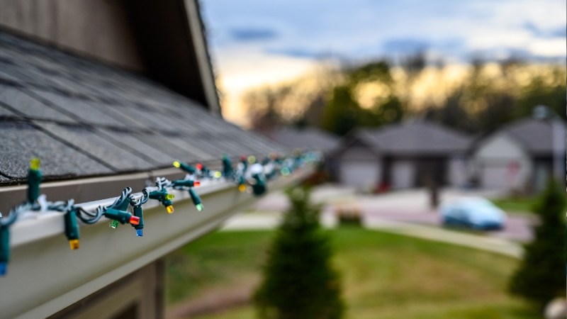 Unlit, multicolored lights stretch across a home's gutter