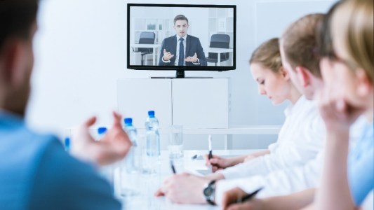 Stock photo of a man having a tele-meeting with a group of doctors