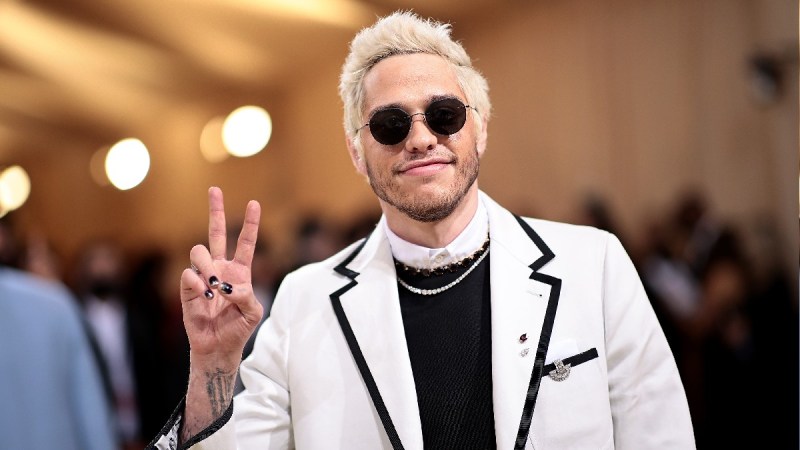 Pete Davidson wears a white jacket over a black dress at the 2021 Met Gala