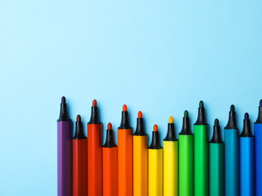 Different colored markers on a blue background