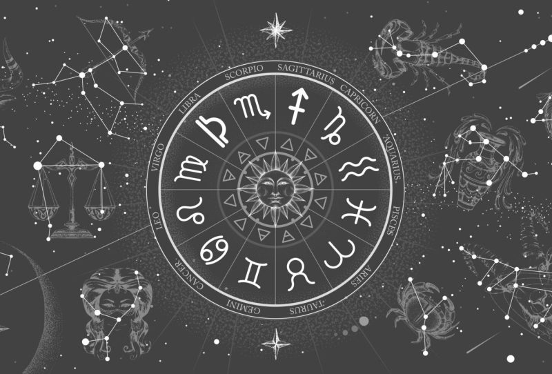 Astrology wheel with zodiac signs on constellation map background.
