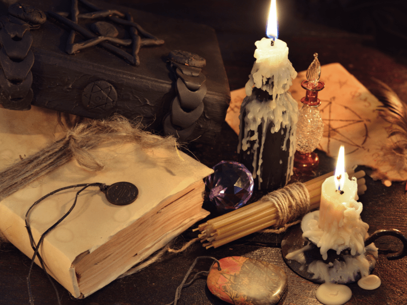 Magic books with wax melted candles, medallions and a crystal ball.