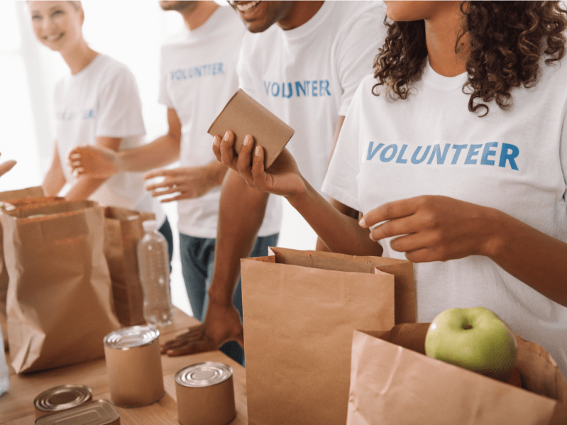 A group of volunteers pack cans of food at a food drive