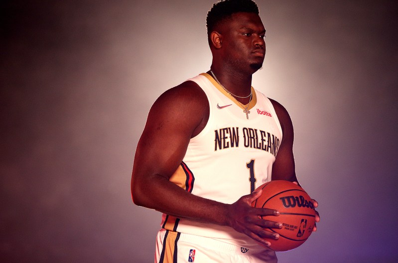 Zion Williamson in a Pelicans uniform holding a basketball.