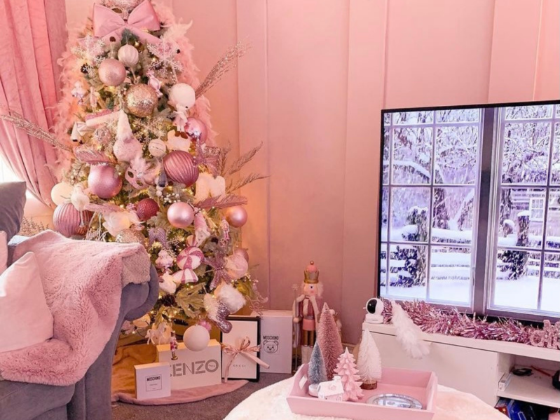 A pastel pink room with a christmas tree covered in pastel ornaments
