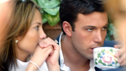 Jennifer Lopez looks at Ben Affleck as he sips from a teacup