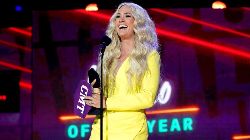 Carrie Underwood wears a yellow dress on stage