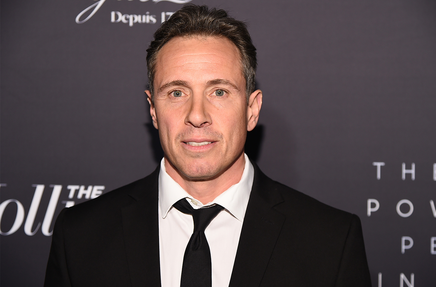 Chris Cuomo wearing a dark suit with his tie slightly loosened
