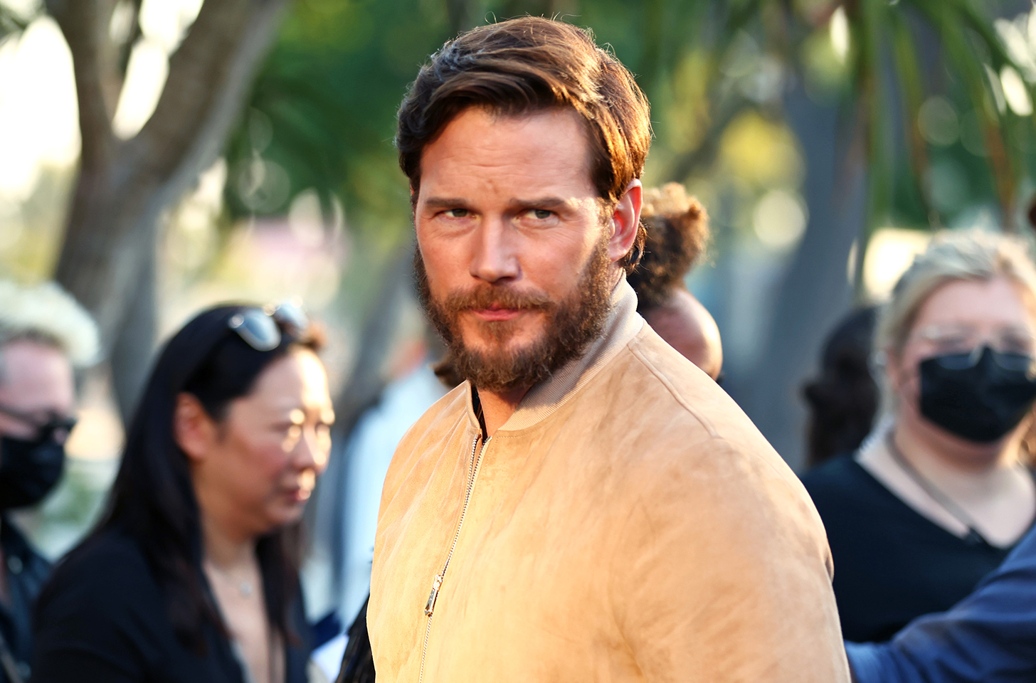 Chris Pratt looking at the camera in a yellow shirt