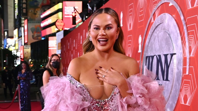Chrissy Teigen wears a silver and pink dress on the red carpet