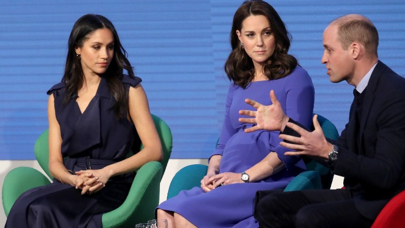Meghan Markle, Kate Middleton, and Prince William sit onstage together during a royal event