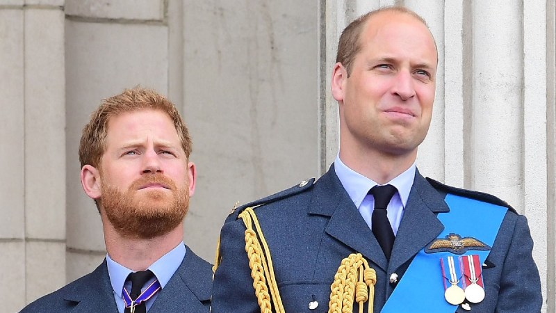 Prince Harry stands in the background behind Prince William as the two gather with the royal family on a balcony