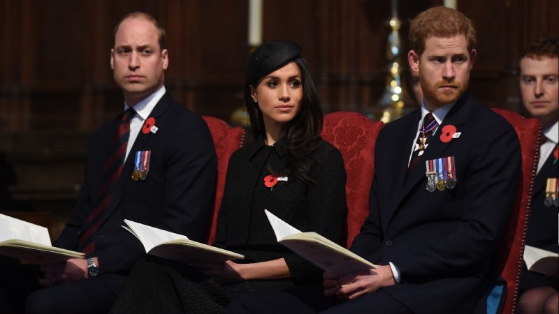 Prince William, Meghan Markle, and Prince Harry wear dark clothes and sit inside a church