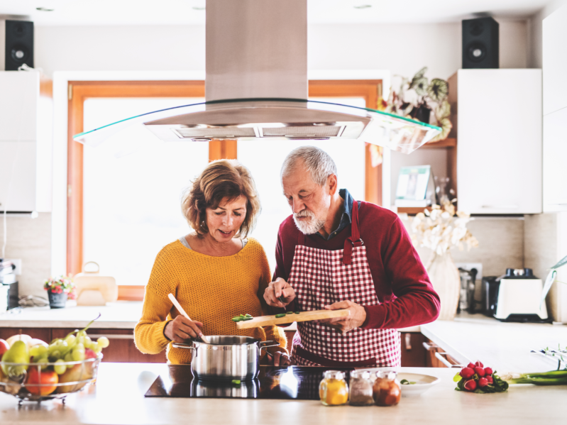 An older couple cooking in their kitchen