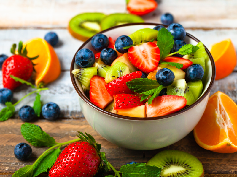A bowl of fruit salad including strawberries, kiwi, blueberries, and other fruits