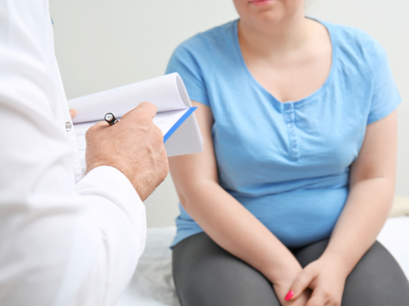 Overweight woman discussing test results with doctor in hospital