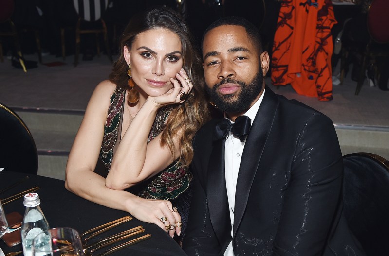 Jay Ellis and Nina Senicar sitting together at a table in formal wear.