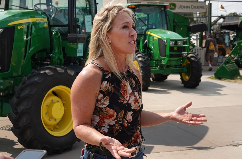 Marjorie Taylor-Greene speaking in front of John Deere tractors