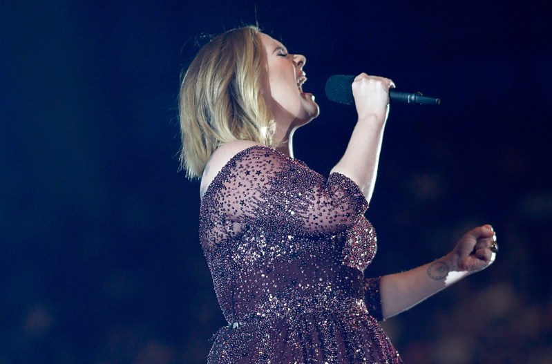Adele performing on stage in a purple dress
