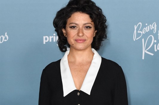 Alia Shawkat in a black dress with a white collar.