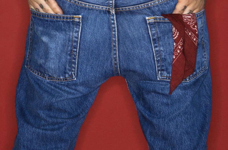 A man wearing jeans with a red bandana in his rear pocket
