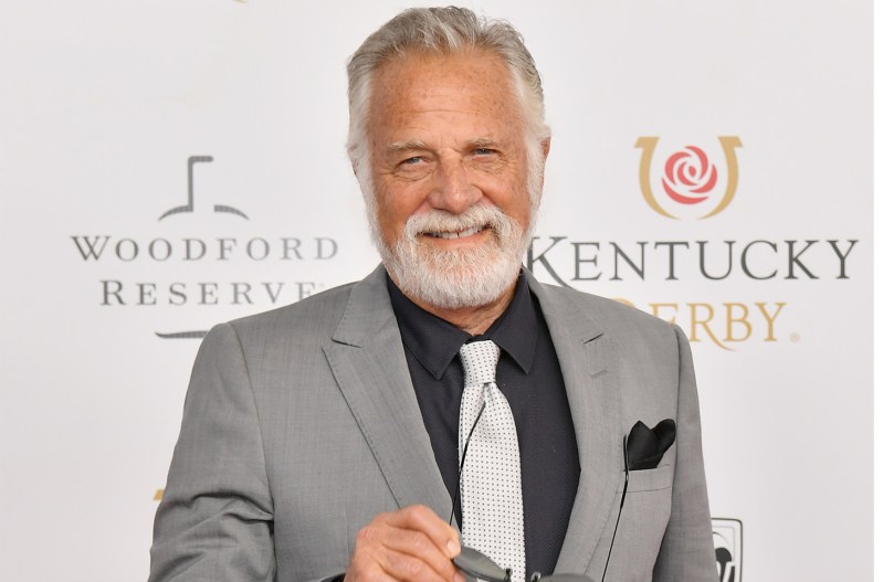 The World's Most Interesting Man Jonathan Goldsmith wearing a grey suit with a black shirt and grey tie