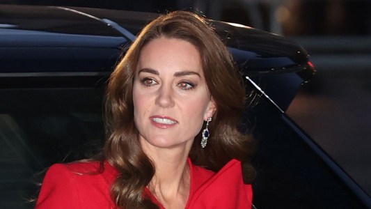 Kate Middleton exits her car while wearing a red dress for a Christmas royal event