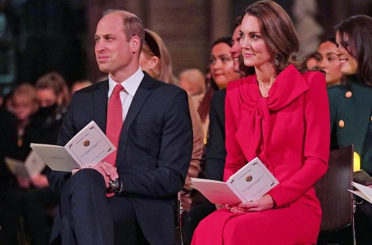 Prince William on the right sitting with Kate Middleton at a Christmas concert