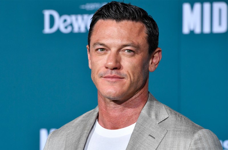 Luke Evans in a grey jacket over a white tee-shirt