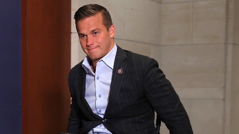 Madison Cawthorn moves through the Capitol while wearing a dark suit