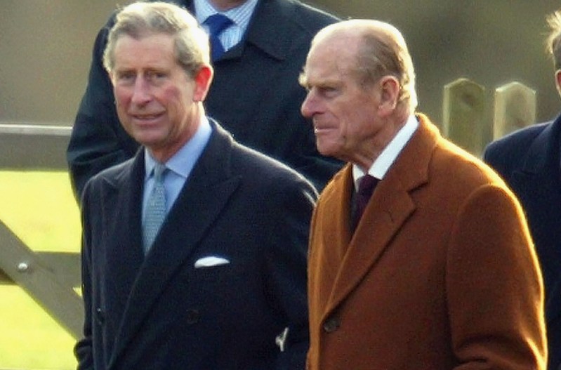 Prince Charles on the left, walking with Prince Philip