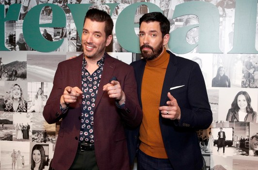 Jonathan Scott on the left, Drew Scott on the right, both pointing at the camera