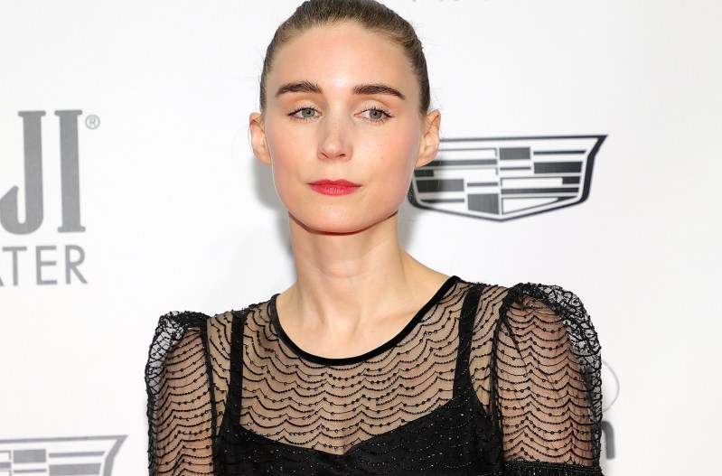 Rooney Mara looking serious in a black dress.