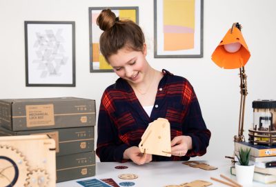 Young teen girl building a mechanical lock box from a KiwiCo crate.